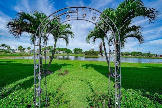 surrounding community featuring a water view and a lawn