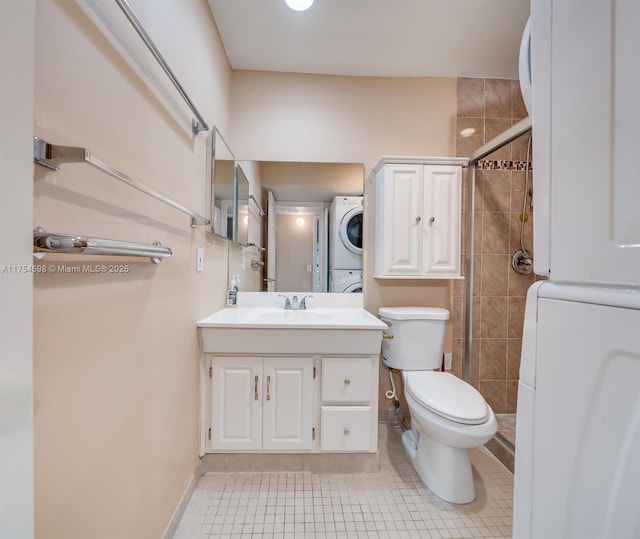 full bathroom with toilet, stacked washer / dryer, a tile shower, vanity, and tile patterned floors