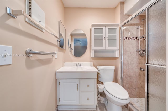 bathroom with toilet, a shower stall, and vanity