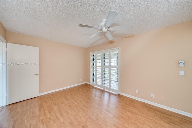 unfurnished room with light wood-style floors, baseboards, and a textured ceiling