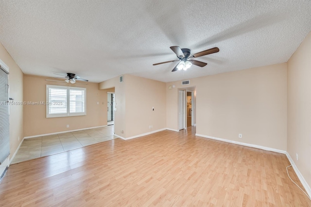 empty room with baseboards, ceiling fan, visible vents, and light wood-style floors