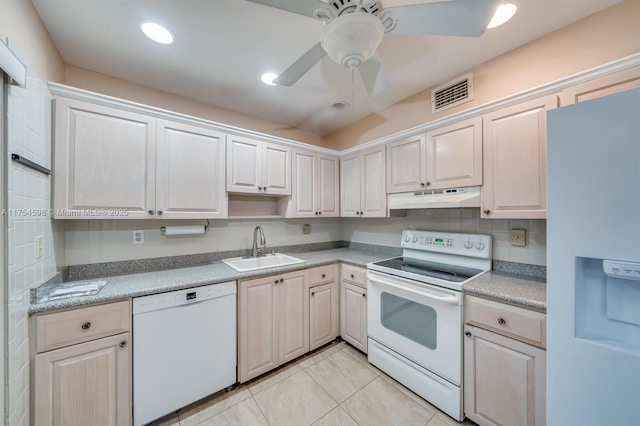 kitchen with under cabinet range hood, white appliances, a sink, visible vents, and backsplash