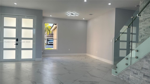 unfurnished room featuring marble finish floor, recessed lighting, baseboards, and french doors