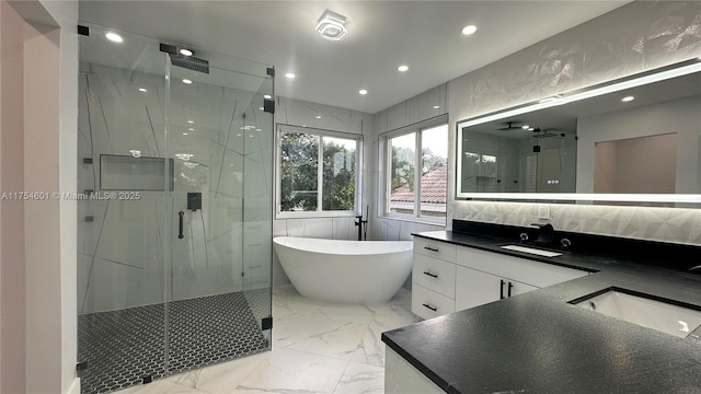 full bath with marble finish floor, double vanity, a stall shower, and a sink