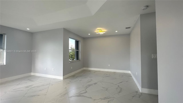 empty room featuring marble finish floor, recessed lighting, visible vents, and baseboards