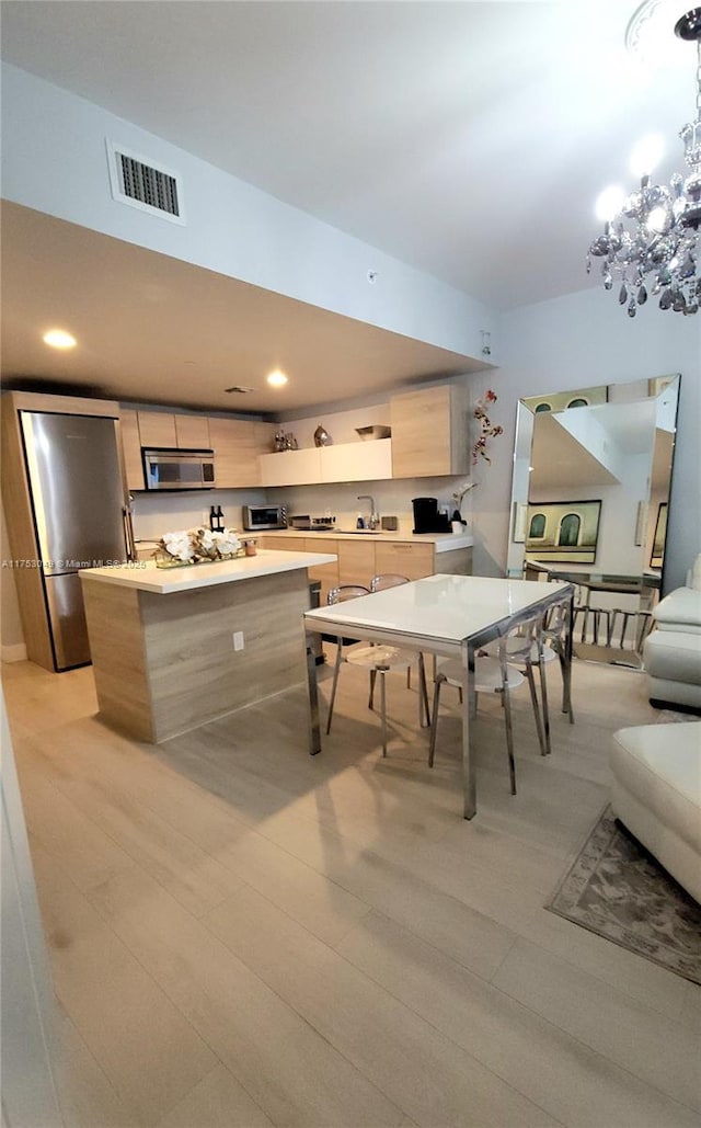 game room featuring recessed lighting, visible vents, light wood-style flooring, a sink, and a chandelier