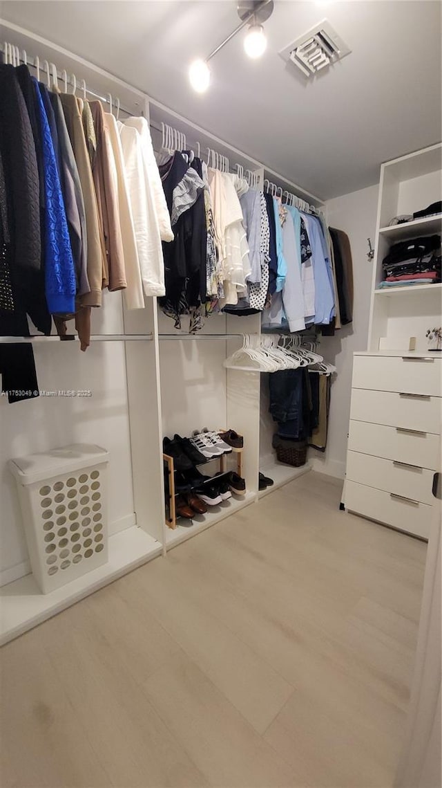 walk in closet featuring visible vents and wood finished floors