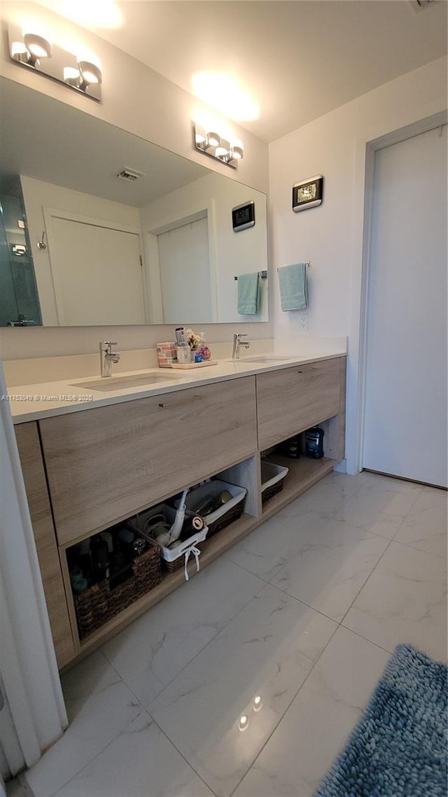 full bath with marble finish floor, visible vents, a sink, and double vanity