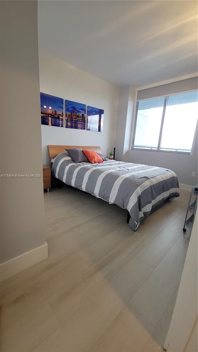 bedroom featuring baseboards and wood finished floors