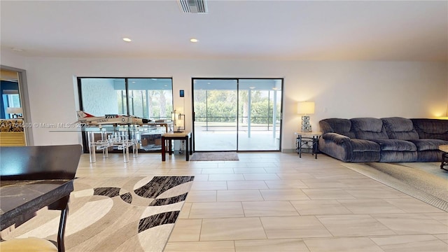 living room featuring light tile patterned floors, visible vents, and recessed lighting