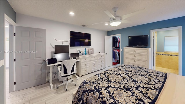 bedroom featuring a textured ceiling, ceiling fan, visible vents, and ensuite bathroom