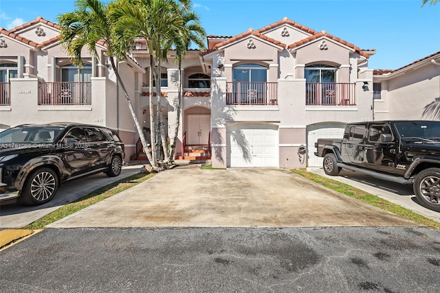 view of front of house featuring stucco siding, a garage, concrete driveway, and a tile roof