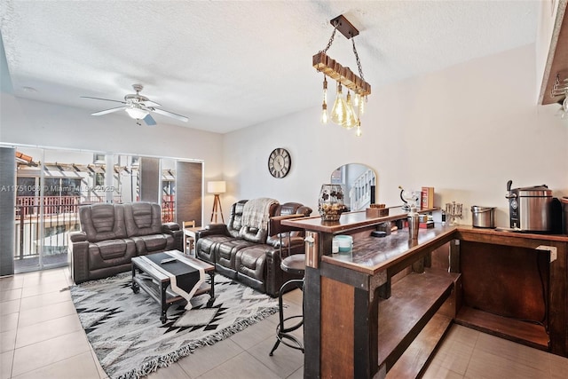 living area featuring vaulted ceiling, ceiling fan with notable chandelier, tile patterned floors, and a textured ceiling