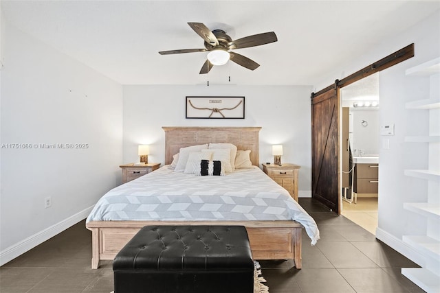 tiled bedroom with ensuite bath, baseboards, a barn door, and a ceiling fan