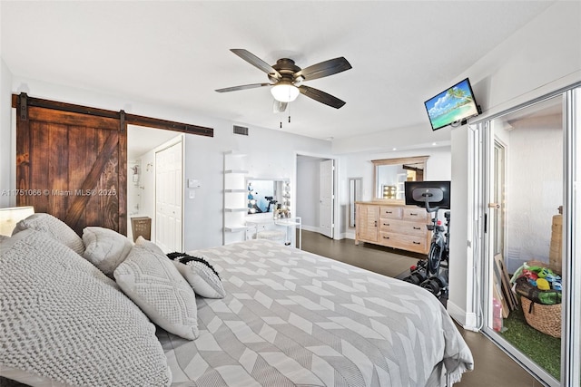 bedroom featuring a barn door, a ceiling fan, visible vents, and baseboards