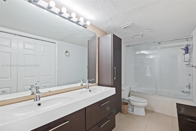 full bathroom with tile patterned flooring, visible vents, toilet, a textured ceiling, and a sink