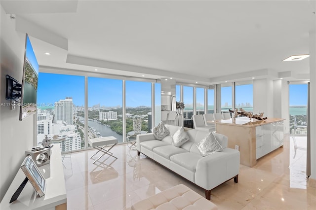 living area featuring plenty of natural light, a view of city, floor to ceiling windows, and recessed lighting