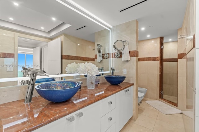 full bathroom featuring toilet, tile patterned flooring, a sink, and tile walls