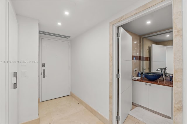 hallway with recessed lighting, visible vents, and a sink