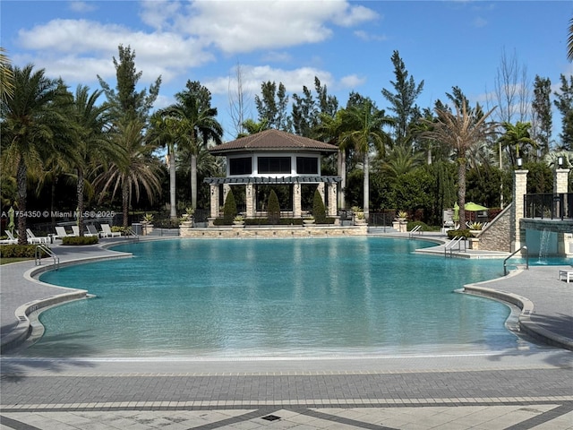 community pool featuring fence, a pergola, and a patio