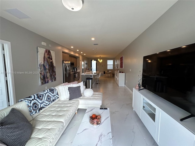 living room featuring baseboards, marble finish floor, and recessed lighting