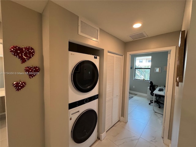 clothes washing area with laundry area, marble finish floor, visible vents, and stacked washer / drying machine