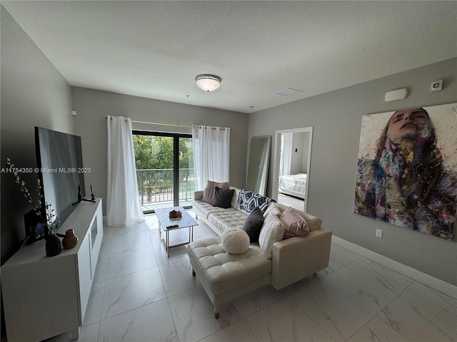 living room featuring marble finish floor, a textured ceiling, and baseboards