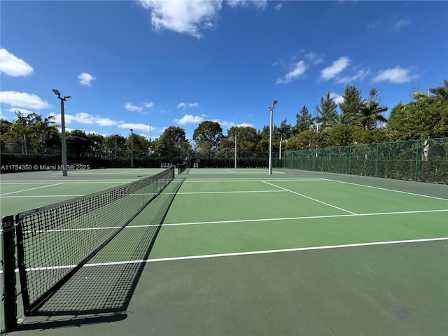 view of tennis court featuring fence