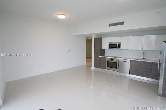 kitchen with visible vents, modern cabinets, appliances with stainless steel finishes, light countertops, and a sink