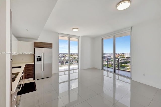 1010 SW 2nd Ave Unit Lph05, Miami, FL 33130 - kitchen featuring fridge with ice dispenser, a wall of windows, light countertops, a city view, and light tile patterned flooring
