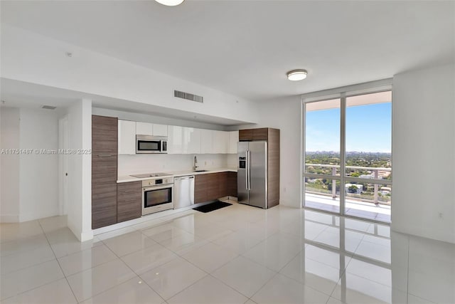 1010 SW 2nd Ave Unit Lph05, Miami, FL 33130 - kitchen featuring stainless steel appliances, a sink, light countertops, modern cabinets, and expansive windows
