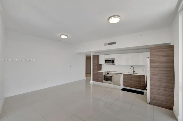 1010 SW 2nd Ave Unit Lph05, Miami, FL 33130 - kitchen featuring appliances with stainless steel finishes, a sink, light countertops, white cabinetry, and modern cabinets
