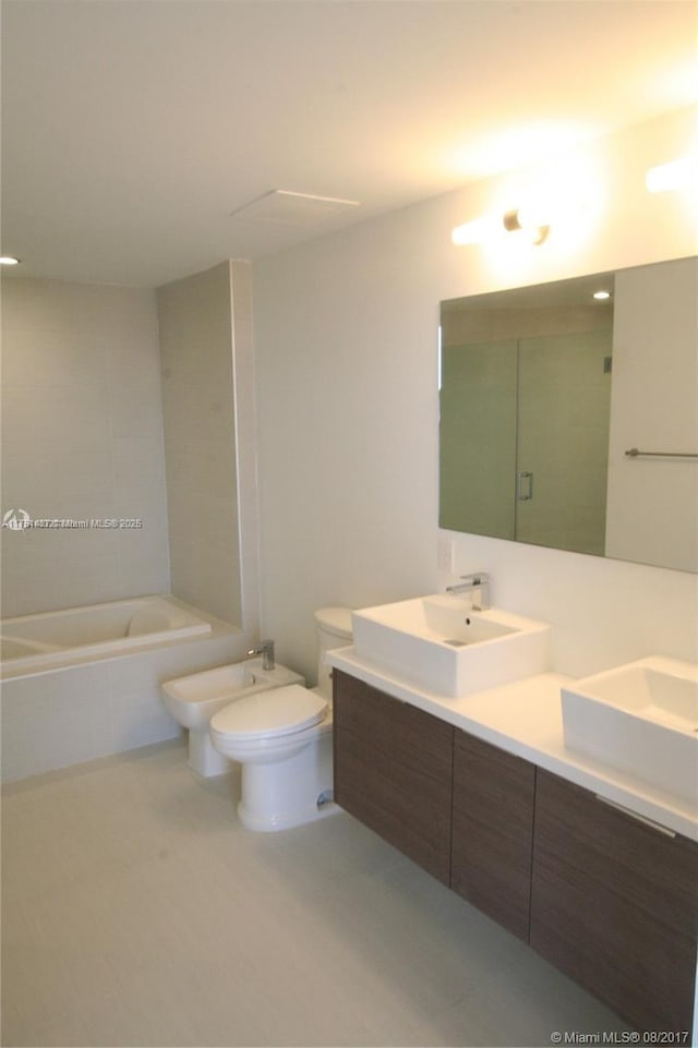 bathroom with a sink, a tile shower, double vanity, a bidet, and tiled tub