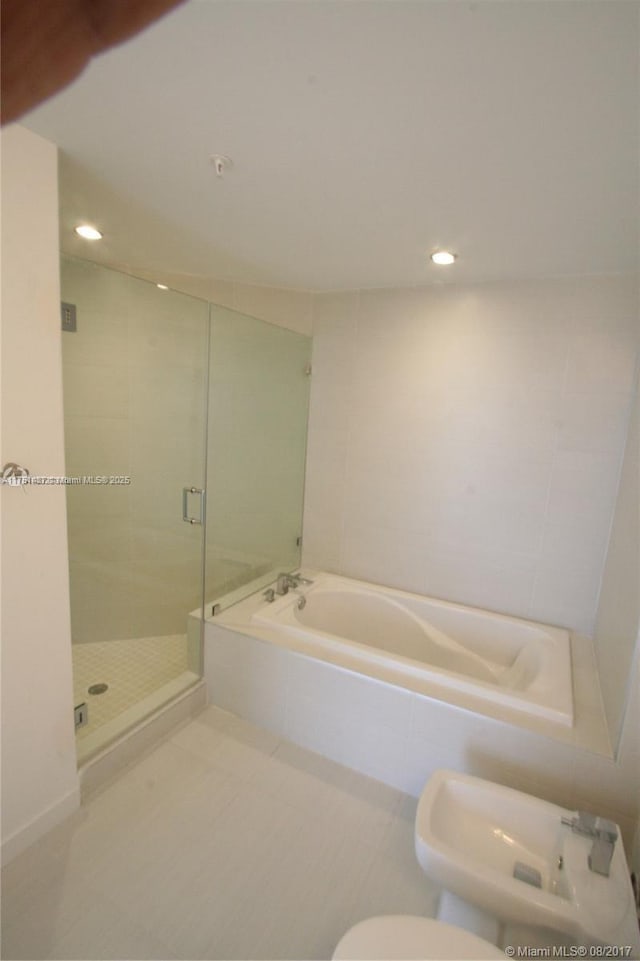 bathroom featuring a stall shower, a garden tub, tile patterned flooring, a bidet, and recessed lighting