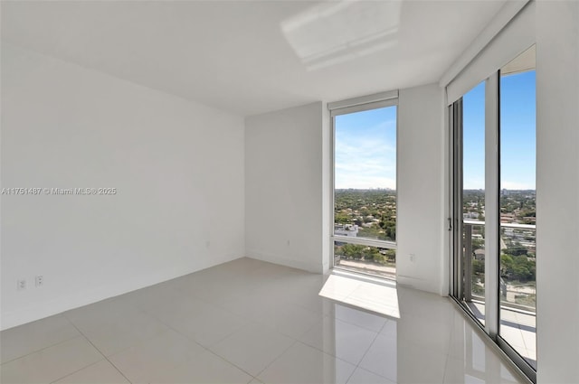 1010 SW 2nd Ave Unit Lph05, Miami, FL 33130 - empty room with healthy amount of natural light, light tile patterned flooring, expansive windows, and baseboards