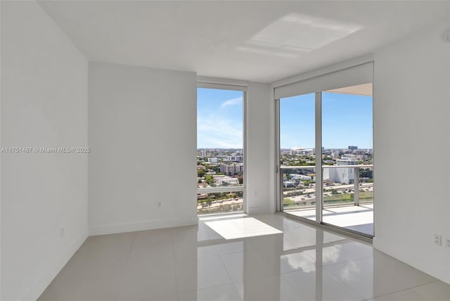 1010 SW 2nd Ave Unit Lph05, Miami, FL 33130 - empty room with baseboards, a city view, floor to ceiling windows, and light tile patterned floors