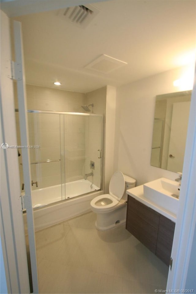 full bathroom featuring visible vents, vanity, toilet, and bath / shower combo with glass door