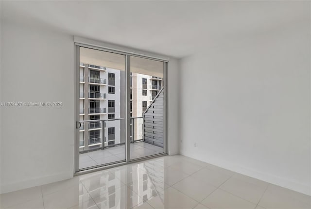 1010 SW 2nd Ave Unit Lph05, Miami, FL 33130 - tiled empty room featuring expansive windows and baseboards