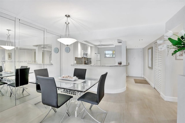 dining room with baseboards and a ceiling fan