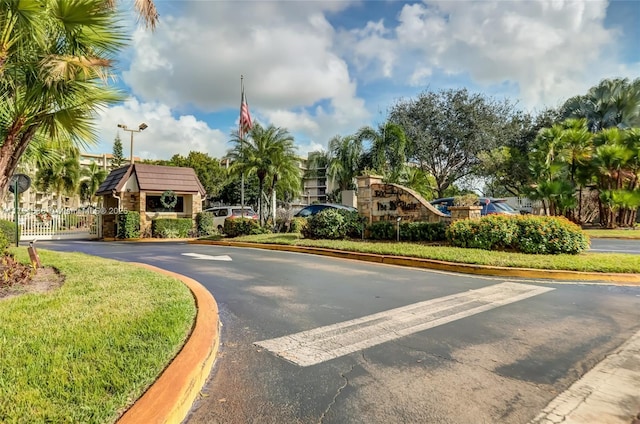 view of street with a gate, curbs, a gated entry, and street lights