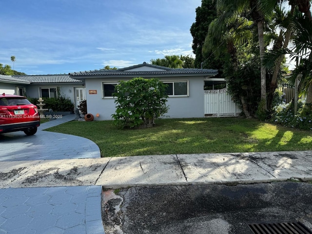 view of front of property with a front lawn, fence, and stucco siding