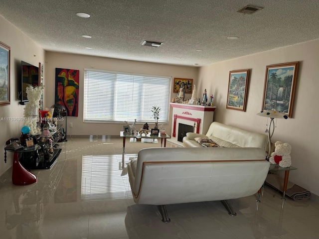 tiled living room featuring visible vents, a fireplace, and a textured ceiling