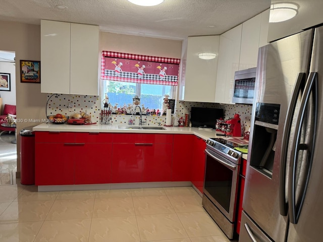 kitchen with light countertops, decorative backsplash, appliances with stainless steel finishes, a sink, and modern cabinets