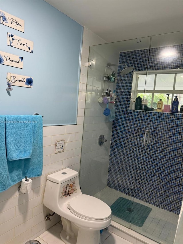 bathroom featuring toilet, a shower stall, and tile walls