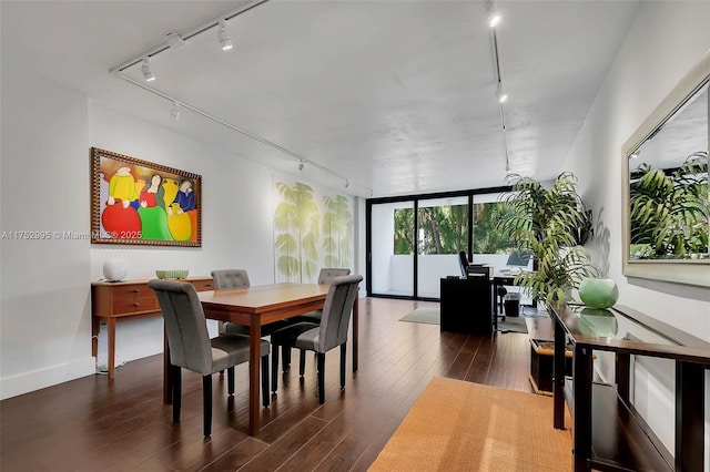 dining area with rail lighting, dark wood finished floors, and a wall of windows