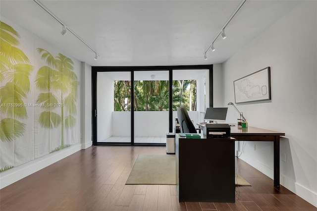 office space with baseboards, a wall of windows, wood finished floors, and track lighting