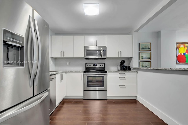 kitchen featuring stainless steel appliances, dark wood-style flooring, white cabinetry, and decorative backsplash