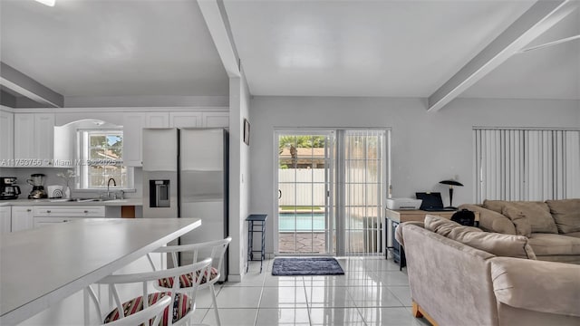 living area featuring light tile patterned floors and beamed ceiling