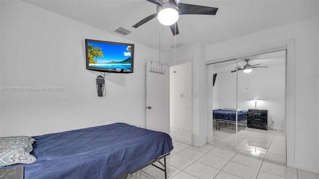 tiled bedroom with lofted ceiling, a closet, visible vents, and a ceiling fan