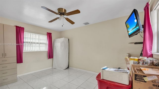 empty room with visible vents, baseboards, a ceiling fan, and light tile patterned flooring